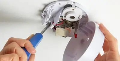 Certified technician wiring smoke detector during installation in Raleigh, NC